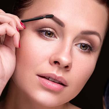 Blonde woman using the Eyebrow Gel